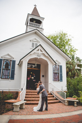 bride and groom kissing in front of chapel